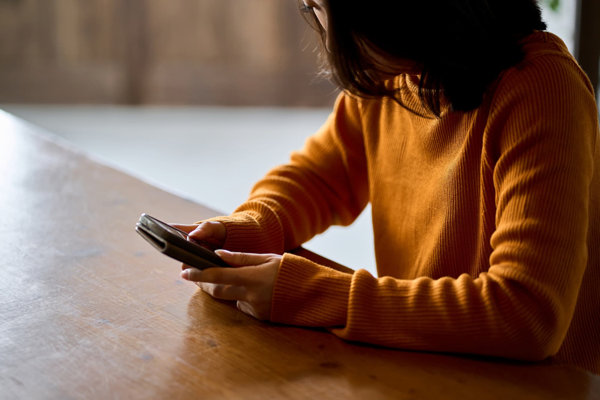 スマホを手に悩む女性